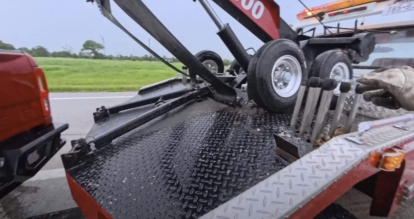 Tow truck operator providing roadside battery replacement service